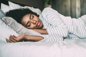 Woman sleeping on bed Image credit: AdobeStock/DavidPrado