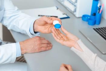 Doctor handing patient contact lens container Image credit: AdobeStock/LIGHTFIELDSTUDIOS