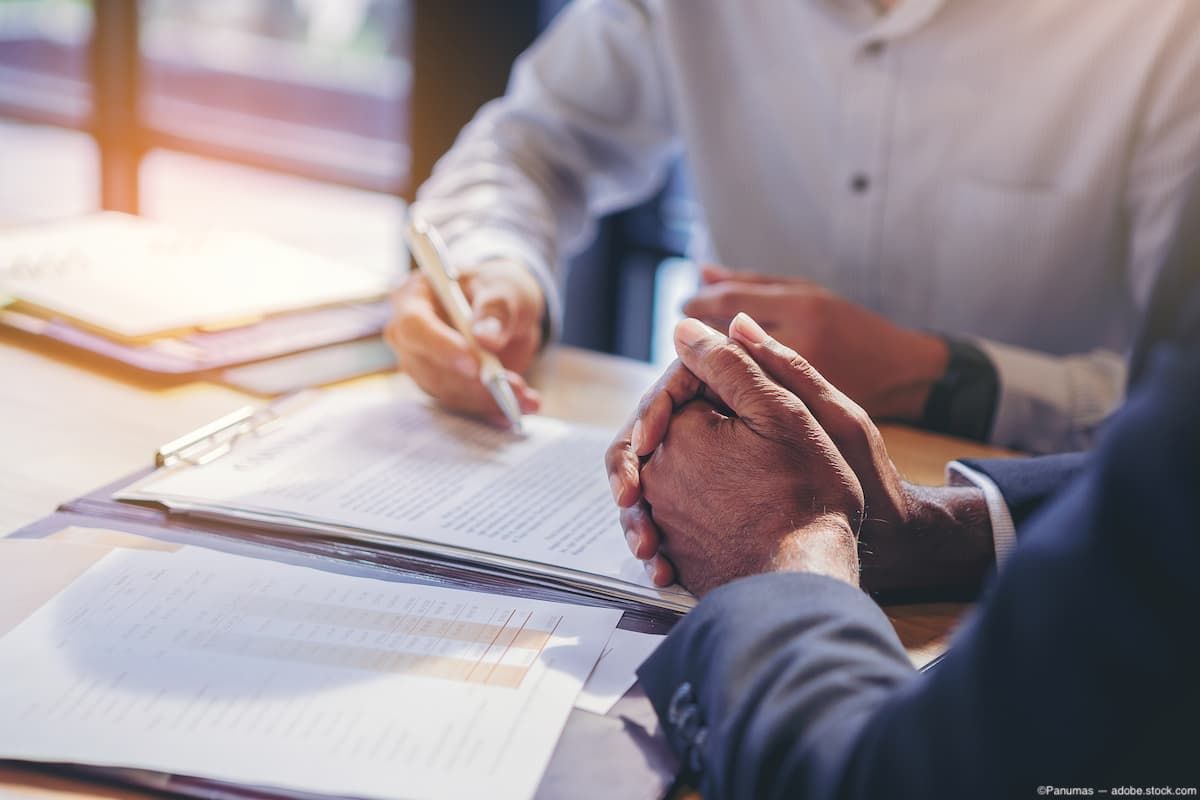 Men at desk making business deal Image credit: AdobeStock/Panumas