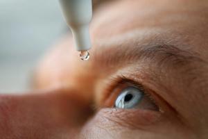 Older person administering eye drop Image credit: AdobeStock/megaflopp