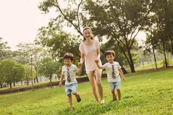 Woman with twin sons in park Image credit: AdobeStock/Photo-maxx