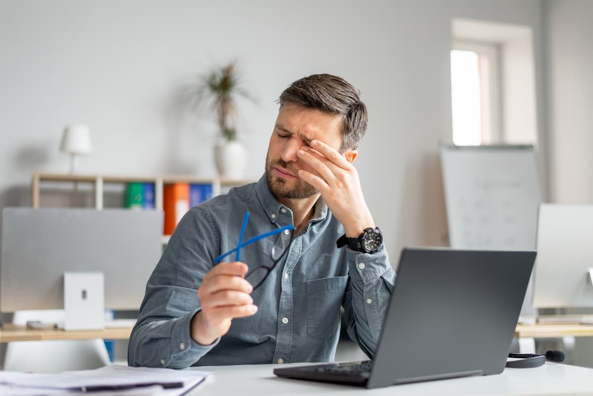 Man rubbing eyes at computer Image credit: AdobeStock/Prostock-studio