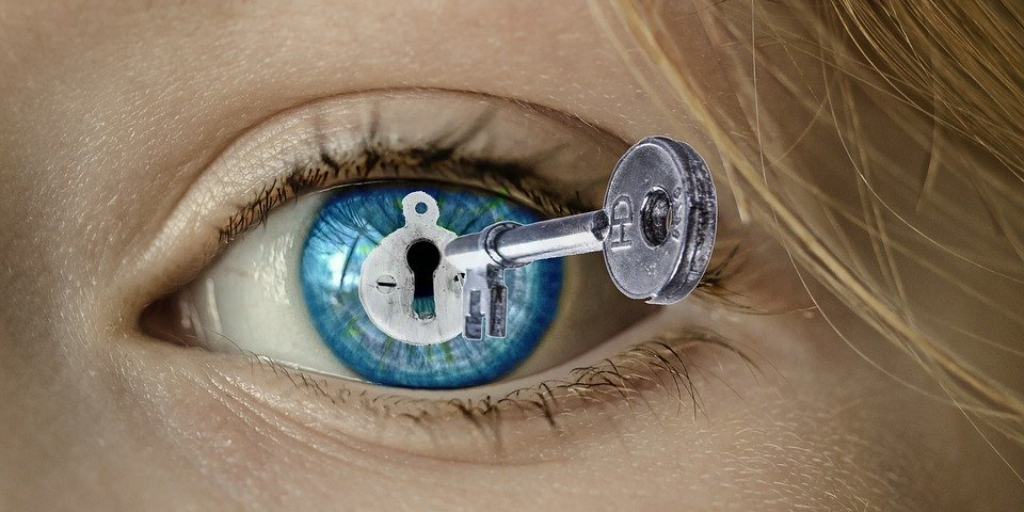 eye with lock superimposed over pupil is being opened with key