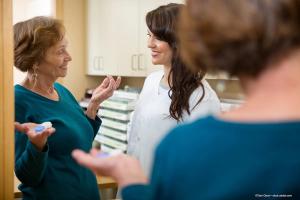 woman discusses contact lenses with optometrist - Image credit: Adobe Stock/Tyler Olson