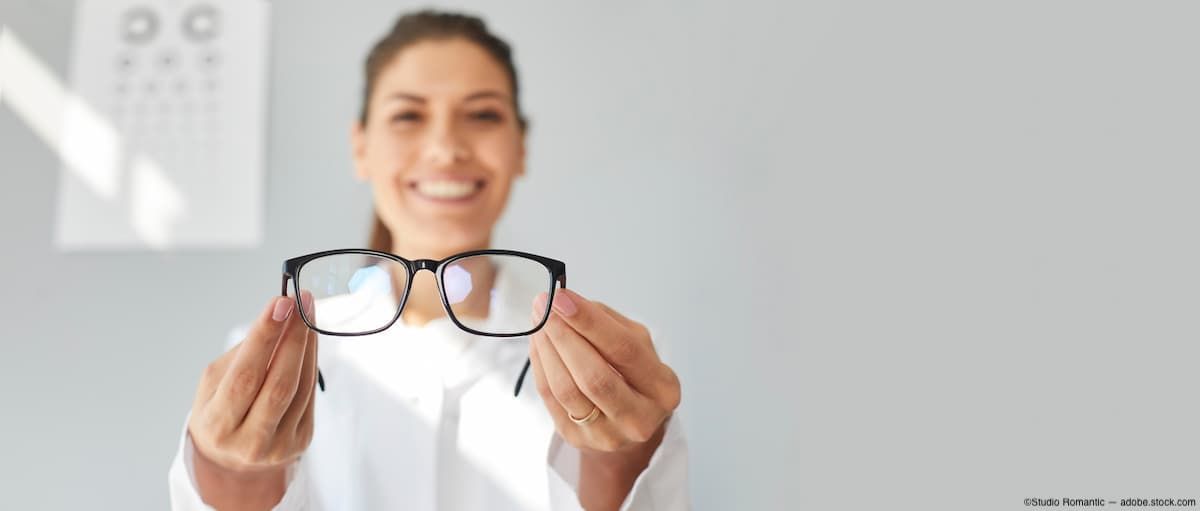 Eye doctor holding out eyeglasses Image credit: AdobeStock/StudioRomantic