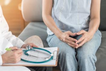Woman sitting with doctor Image credit: AdobeStock/Chinnapong