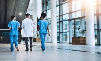 Doctors walking together down hallway Image credit: AdobeStock/Donson/peopleimages.com