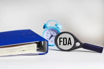 FDA in magnifying glass with binder Image credit: AdobeStock/Sviatlana