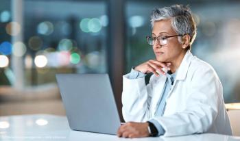 Laptop, doctor and senior woman in hospital working late or overtime on email, telehealth or research. Bokeh, thinking and female medical physician reading healthcare information at night on computer (Adobe Stock / C Malambo/peopleimages.com)