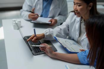 Doctors discussing data Image credit: AdobeStock/Phimwilai
