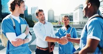 Group of doctors shaking hands Image credit: AdobeStock/peopleimages.com