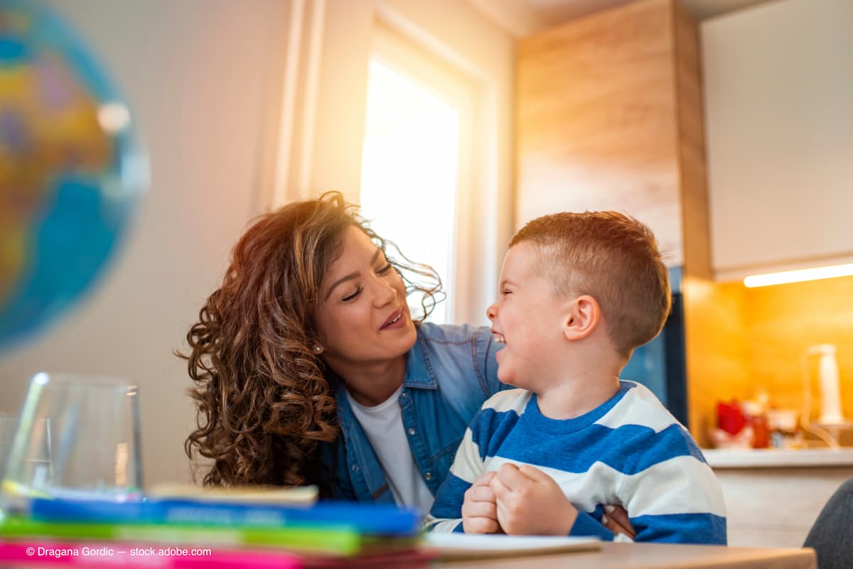 Mother helping her son doing homework in kitchen. Mother Helping Son With Homework At Table. Children's creativity. Portrait of smiling mother helping son with homework in kitchen at home (Adobe Stock / Dragana Gordic)