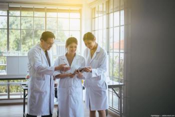 Three doctors looking at report in office Image credit: ©gballgiggs - adobe.stock.com