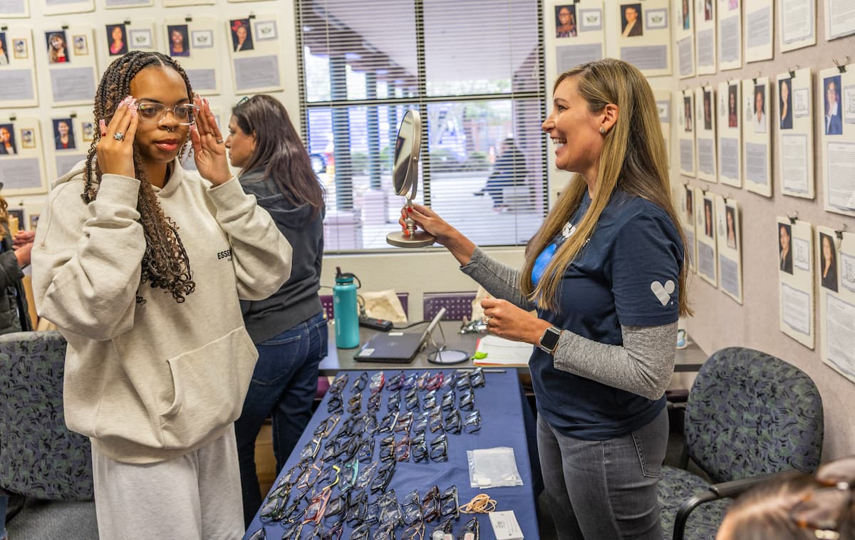 VSP volunteer (right) helps a patient try on new frames at VSP Vision's first event in part of its 70-event tour. Image credit: VSP Vision