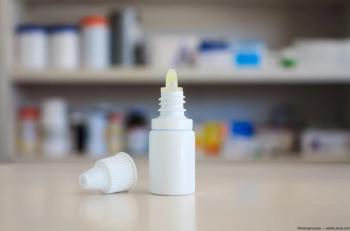 Eye drop application bottle on table. Image credit: AdobeStock/Kwangmoozaa
