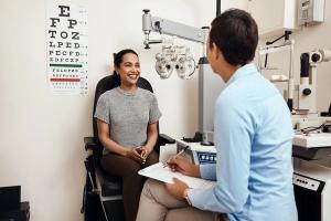 Eye doctor speaking to patient in chair Image credit: AdobeStock/NicholasFelix/peopleimages.com