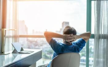 Man looking out window in office Image credit: AdobeStock/Chinnapong