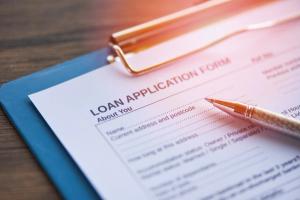 Loan application form on clipboard Image credit: AdobeStock/BigcStudio