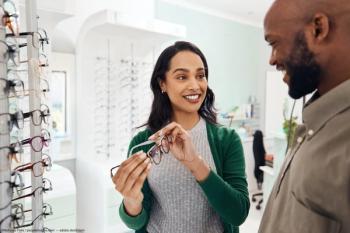Optician holding up frames for patient Image credit: AdobeStock/NicholasFelix/peopleimages.com