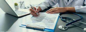 Doctor filling out paper medical record. Image credit: AdobeStock/InfiniteFlow