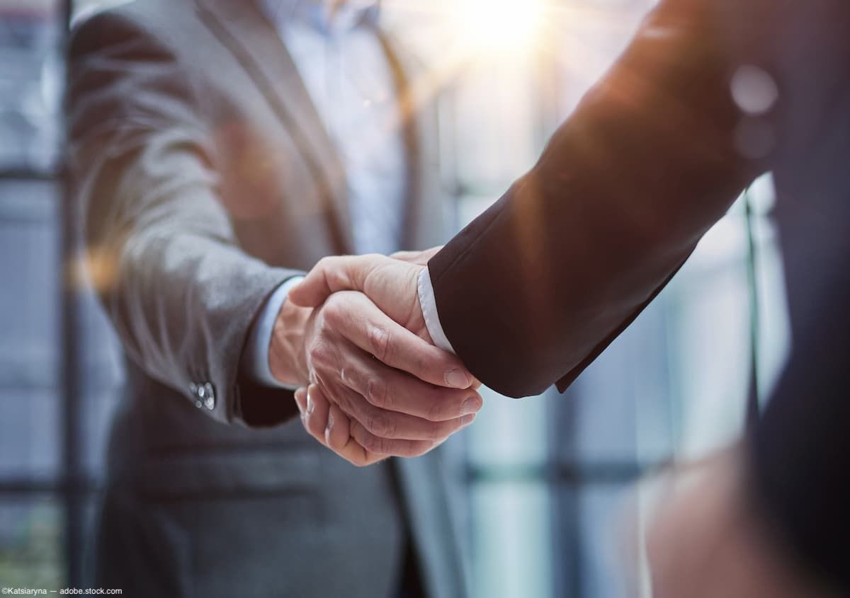 Two businessmen shake hands Image credit: AdobeStock/Katsiaryna