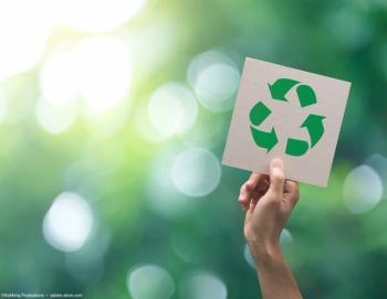 Person holding recycling sign Image credit: AdobeStock/NaMongProductions