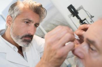 Doctor administering eye drops to patient Image credit: AdobeStock/auremar