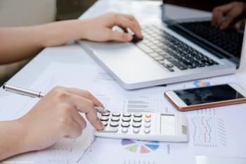 Person at desk with computer and calculator 