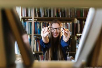 Woman with glasses in library Image credit: ©Татьяна Скорина - adobe.stock.com