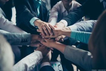 Business people putting hands in middle of a huddle Image credit: AdobeStock/deagreez