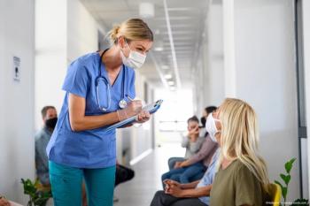 Physician speaking to patient in waiting room Image credit: ©Halfpoint - adobe.stock.com