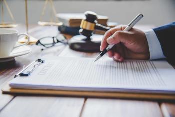 Lawyer writing at desk Image credit: AdobeStock/photobyphotoboy