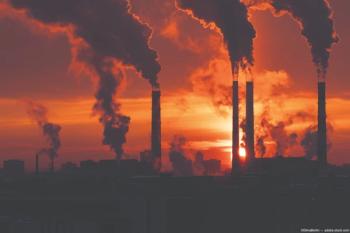 Smoke stacks at a factory. Image credit: AdobeStock/DimaBerlin