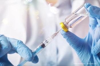 gloved hands holding a vaccine injection (Adobe Stock / BillionPhotos.com)