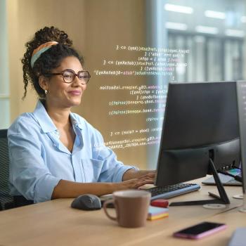 Woman working at desk on computer. Image credit: HOYA Vision Care