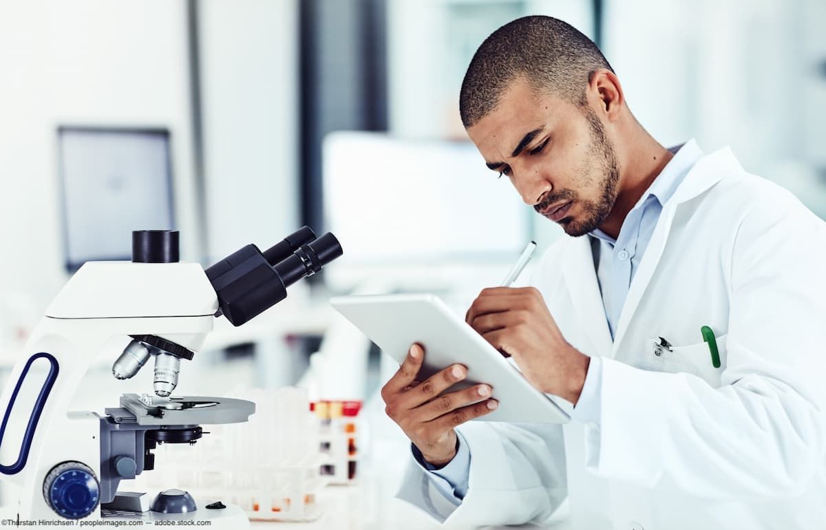 Scientist looking at data on clipboard Image credit: AdobeStock/ThurstanHinrichsen/peopleimages.com