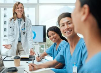 Doctors sitting at table for board meeting Image credit: AdobeStock/KayExam/peopleimages.com