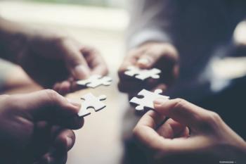 Four hands putting together puzzle pieces Image credit: AdobeStock/Johnstocker