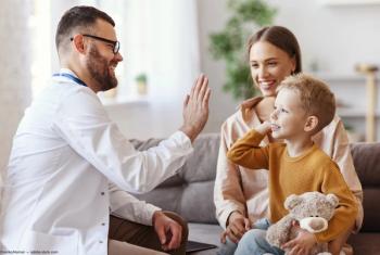 Doctor high-fiving pediatric patient sitting on mother's lap Image credit: ©JenkoAtaman - adobe.stock.com