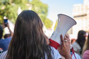 Woman holding bullhorn in crowd Image credit: AdobeStock/CarolinaJaramillo