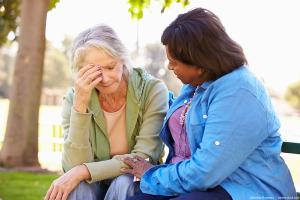 Woman consoling her friend on a park bench AdobeStock/MonkeyBusiness