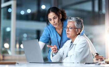Doctors talking at table Image credit: AdobeStock/CMalambo/peopleimages.com