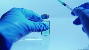 Gloved hand holding vial, needle Image credit: ©desertsands - adobe.stock.com