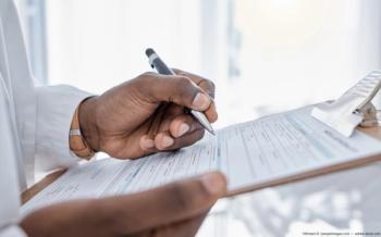 Doctor writing on clipboard Image credit: AdobeStock/KirstenD/peopleimages.com