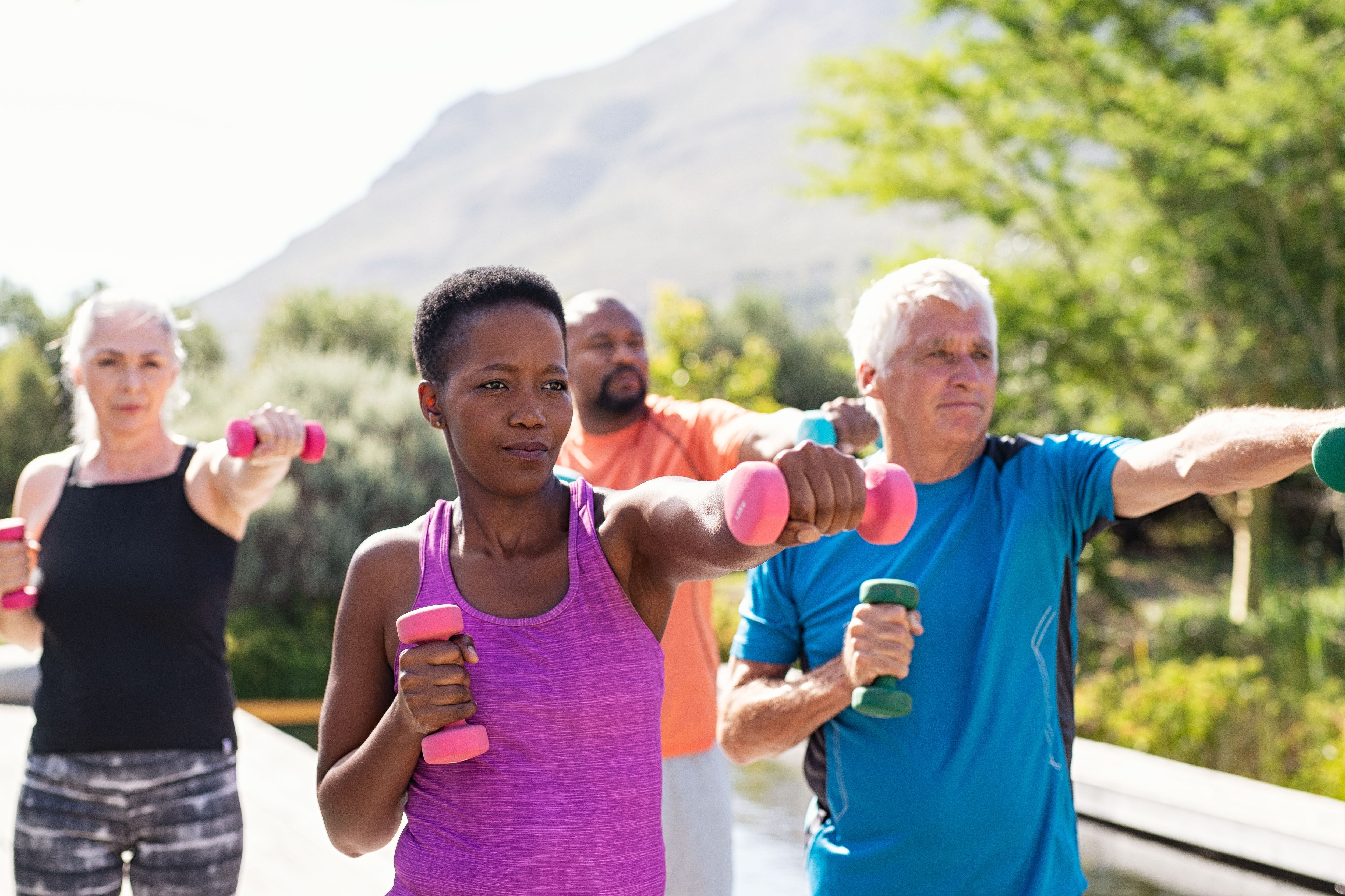 group of older adults outside exercising with weights