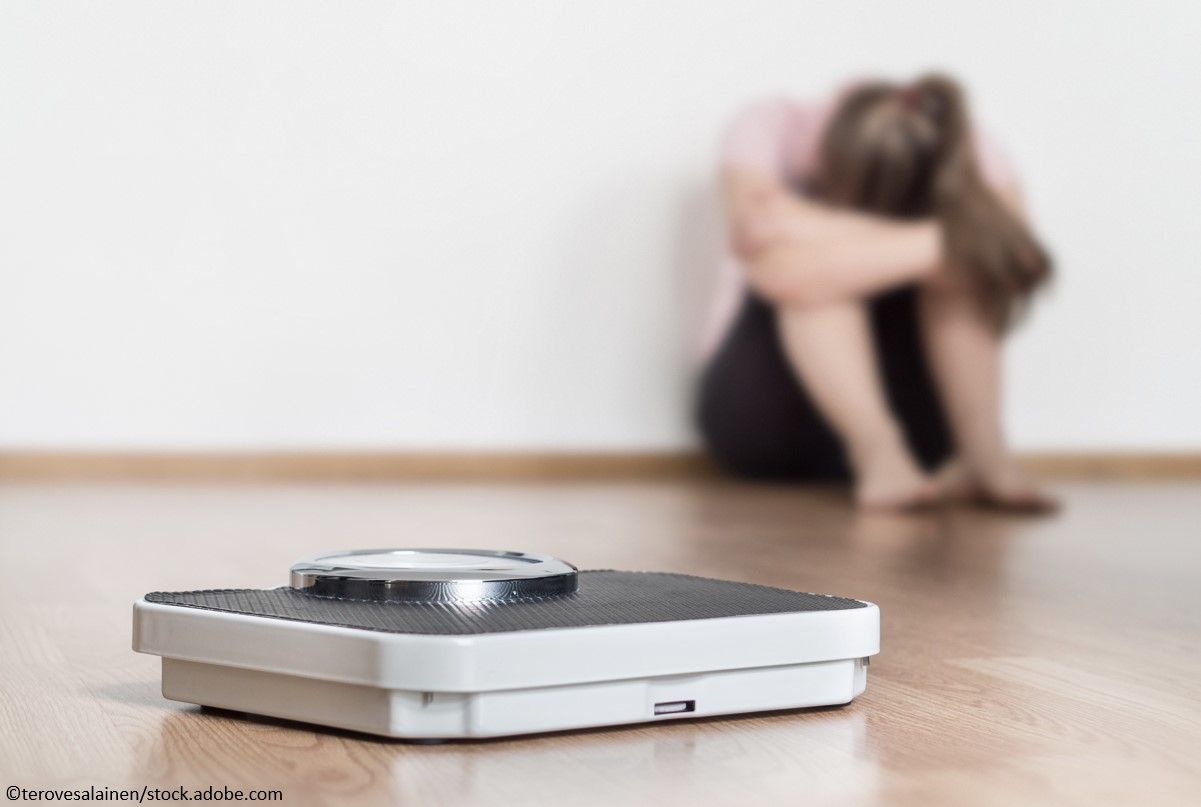 weight, weight stigma, young woman crying next to weight scale
