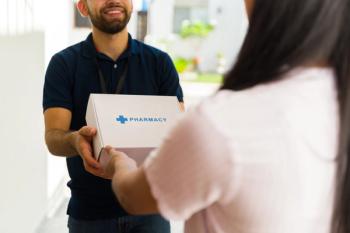 Closeup of a delivery man delivering medication in a white box with the word pharmacy on it to a woman. | © AntonioDiaz - stock.adobe.com
