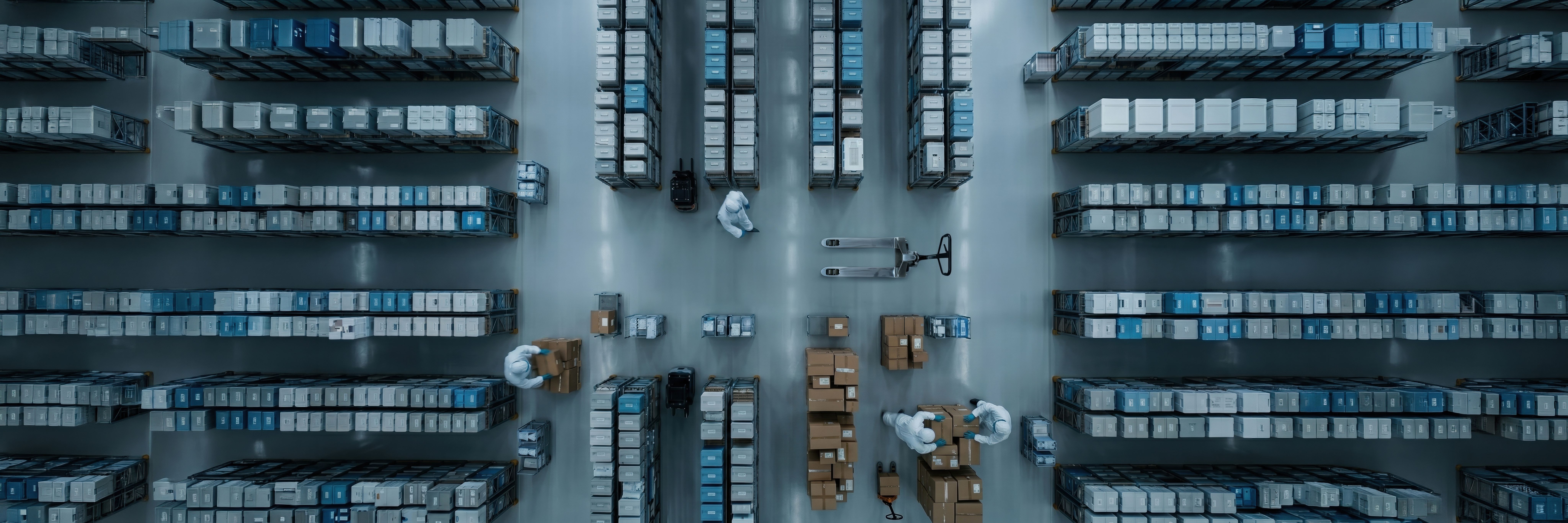 Overhead view of medical warehouse with workers packing supply boxes. Concept of pharma fulfillment, hospital logistics, order picking, and inventory control. | © master1305 - stock.adobe.com (2033896887)