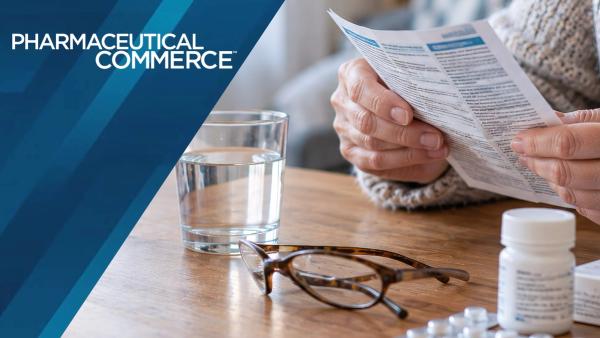 Elderly person read medicine leaflet on wooden table with water glass and pills | Sandor - stock.adobe.com