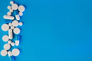 Scattered white pills on blue table. Mock up for special offers as advertising, web background or other ideas. Medical, pharmacy and healthcare concept. Copy space. Empty place for text or logo | ©  volody10 - stock.adobe.com (244162165)